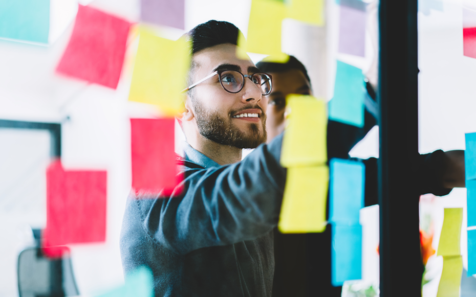 A Gen-Zer stands in front of a wall of sticky notes.